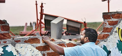A man looks past the damaged compound wall of the Tiruchy airport, which was hit by a plane during take-off; and (right) the damaged belly of the plane in Mumbai  | MK Ashok Kumar