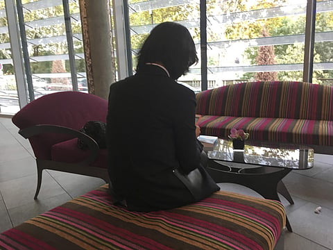 Grace Meng, the wife of missing Interpol President Meng Hongwei, who does not want her face shown, consults her mobile phone in the lobby of a hotel in Lyon, central France, where the police agency is based, on Sunday Oct. 7, 2018. (Photo | AP)