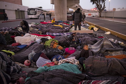 Migrants sleep on a street near the Chaparral border crossing in Tijuana, Mexico. (Photo| AP)