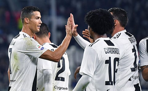 Juventus' Juan Cuadrado celebrates with his teammate Cristiano Ronaldo, left, after scoring his team's third goal during the Italian Serie A soccer match between Juventus and Cagliari at the Allianz Stadium in Turin, Italy, Saturday, Nov. 3, 2018. | AP