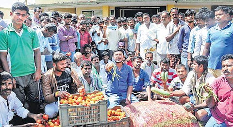 Farmers stage a protest in front of the APMC Yard following a crash in  vegetable prices in Mysuru on Sunday | Udayshankar S