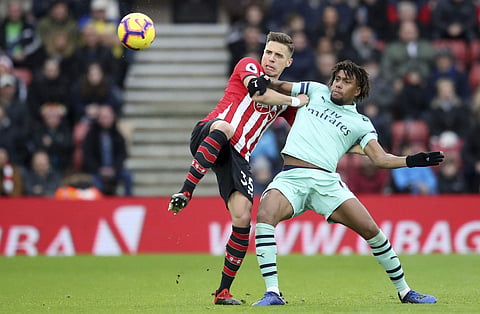 Arsenal's Alex Iwobi, left, and Southampton's Jan Bednarek in action during their English Premier League soccer match at St Mary's Stadium in Southampton, England, Sunday Dec. 16, 2018. | AP