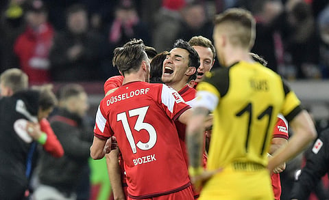 Fortuna's team celebrates behind Dortmund's Marco Reus, right, after the German Bundesliga soccer match between Fortuna Duesseldorf and Borussia Dortmund in Duesseldorf, Germany, Tuesday, Dec. 18, 2018.  | AP