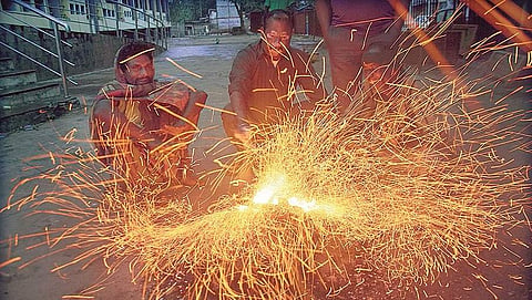 People warming themselves to beat the cold beside a road in Bhubaneswar on Tuesday morning  | Express
