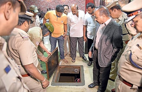 Bengaluru city police commissioner T Suneel Kumar inspects the manhole in which two men died. | (Nagaraja Gadekal | EPS)