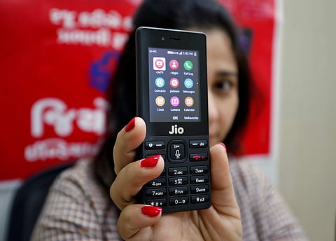 A sales person displays JioPhone as she poses for a photograph at a store of Reliance Industries' Jio telecoms unit on the outskirts of Ahmedabad.
