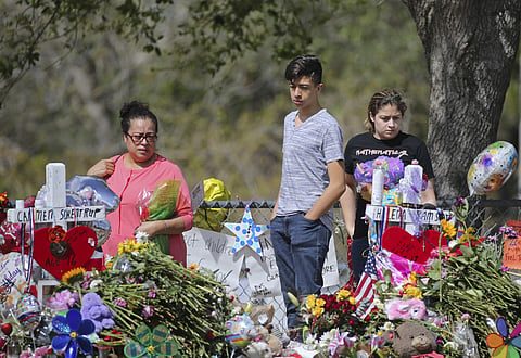 Mourners pay tribute at a memorial for the victims of the shooting at Marjory Stoneman Douglas High School on Sunday, Feb. 25, 2018, in Parkland, Fla. (David Santiago/Miami Herald via AP)