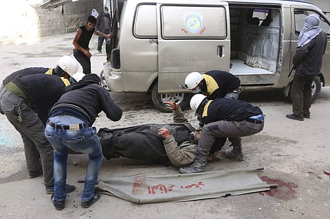 The members of the Syrian Civil Defense group carrying a man who was wounded during airstrikes and shelling by Syrian government forces, in Ghouta, a suburb of Damascus, Syria. | AP