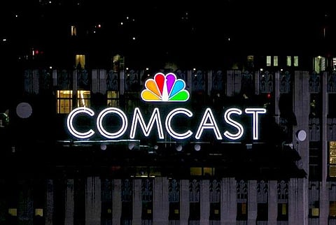 The NBC and Comcast logo are displayed on top of 30 Rockefeller Plaza in New York. (Photo | Reuters