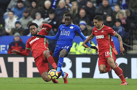 Swansea City's Leroy Fer, left, and teammate Martin Olsson battle with Leicester City's Fousseni Diabate, centre during the English Premier League soccer match between Leicester City and Swansea City. | AP