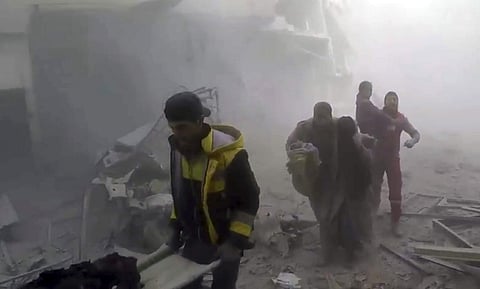 Members of the Syrian Civil Defense group help residents during airstrikes and shelling by Syrian government forces in Ghouta (Photo | AP)