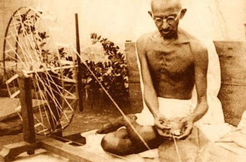 Mahatma Gandhi spinning yarn, in late 1920 (Image courtesy Wikimedia Commons)