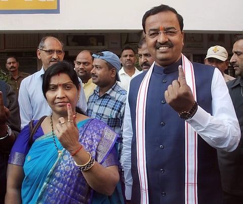Uttar Pradesh Deputy Chief Minister Keshav Prasad Maurya and his wife Raj Kumari Maurya show theirs marked with indelible ink after they cast their votes during Phulpur Lok Sabha by-poll election in Allahabad on Sunday. (PTI)