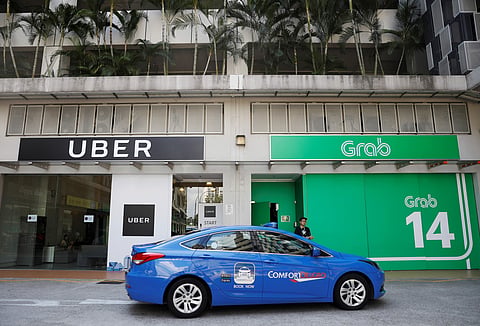 (A ComfortDelgro taxi passes Uber and Grab offices in Singapore March 26, 2018. | Reuters)