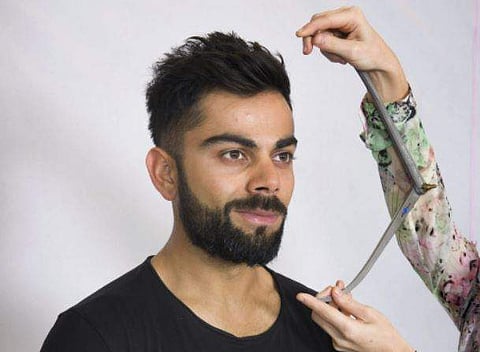 Virat Kohli looks on as a Madame Tussauds artist takes his measurement for a wax statue in New Delhi. | PTI