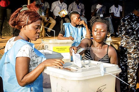 In this Wednesday, March 7, 2018 file photo, a woman casts her vote during the first round of presidential election, outside a polling station in Freetown, Sierra Leone.