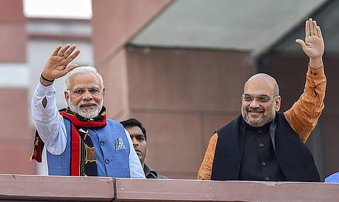 After their victory in North-East Assembly election, Prime Minister Narendra Modi and BJP President Amit Shah wave as they arrive to address BJP party workers at party headquarters in New Delhi. (PTI)