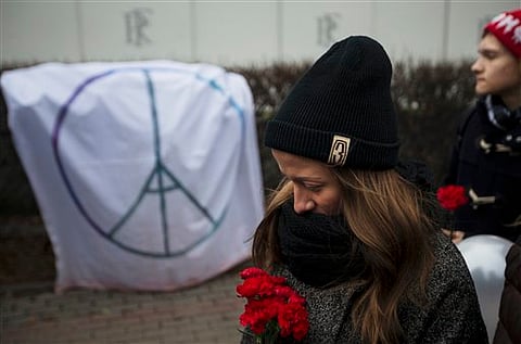 People line up to lay flowers in front of the French embassy in Moscow, Russia, Saturday, Nov. 14, 2015, for the victims of the Paris attacks on Friday.  | AP