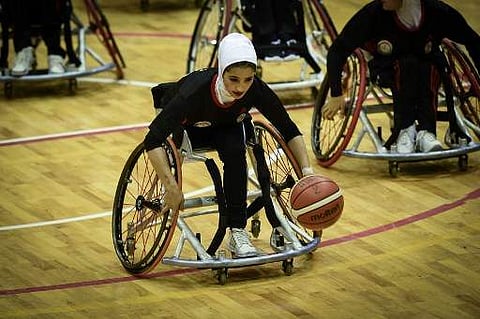 This photo taken on March 7, 2018 shows a member of Afghanistan's women's wheelchair basketball team dribbling the ball during the qualifying tournament for the Asia Para Games in Bangkok.