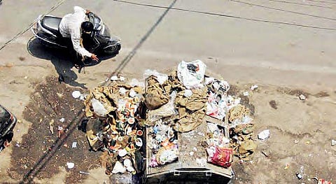 A man throwing waste near a bin overflowing with garbage at Shalibanda in  Old City on Saturday | Sathya keerthi