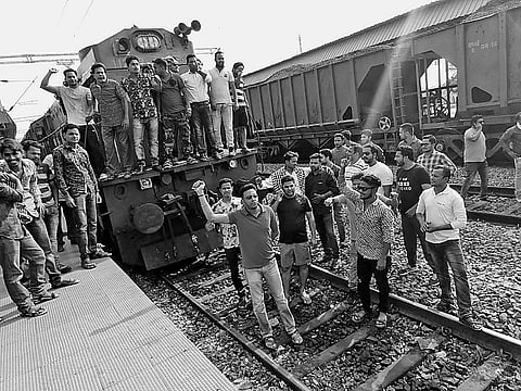 Agitators stop a train at Balangir railway station on Tuesday and vehicles stranded on Highway in Sambalpur | Express