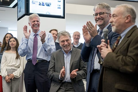 (L-R) Washington Post Publisher Fred Ryan, Executive Editor Marty Baron, and National Security Editor Peter Finn, applaud as investigative reporter Tom Hamburger speaks to the newsroom after The Washington Post wins two pulitzer prizes.  The Post shared a