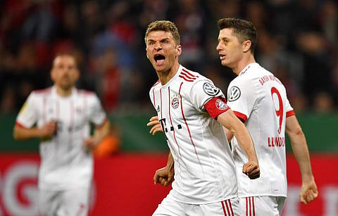 Bayern's Thomas Mueller reacts beside Bayern's Robert Lewandowski, right, after he scored his side's third goal during the German cup semifinal match between Bayer Leverkusen and Bayern Munich. (AP)