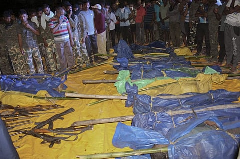 In this Sunday, April 22, 2018 photo, Indian security personnel stand next to bodies of killed Maoist rebels in Rela-Kasnasur forest in Gadchilori district in Maharashtra. (AP)