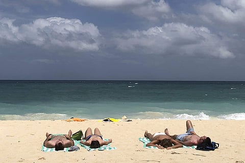 In this March 12, 2018, photo, foreign tourists sunbathe at a beach on Boracay island, central Aklan province, Philippines. | AP