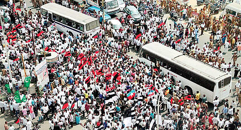 DMK cadre blocking the Labour Statue area in the city on Thursday; and (below) party working president M K Stalin being carried away by the police during the protest | Express