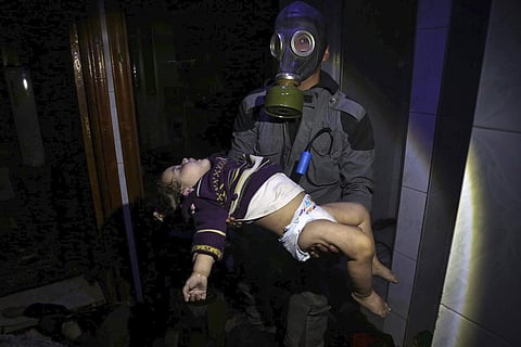 A rescue worker carrying a child following an alleged chemical weapons attack in the rebel-held town of Douma. (Photo | AP)
