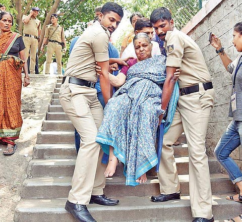 Policemen carry a senior citizen to a polling booth due to the absence  of a wheelchair or ramp at Padmanabhanagar in Bengaluru on Saturday   | Nagaraja Gadekal