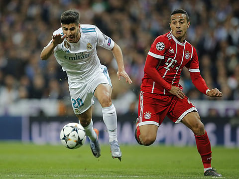 Real Madrid's Marco Asensio, left, and Bayern's Thiago challenge for the ball during the Champions League semifinal second leg match between Real Madrid and FC Bayern Munich at the Santiago Bernabeu stadium in Madrid. (AP)