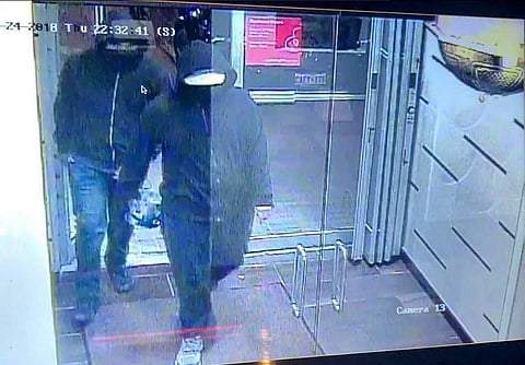 This surveillance camera image released on Peel Regional Police Twitter account (@PeelPoliceMedia)on May 25, 2018, shows two hooded men carrying a device and entering an Indian restaurant in Mississauga, Ontario on May 24 a few minutes before an explosion