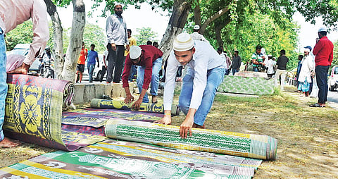 Muslim men roll up namaz mats after they were forced to stop offering Friday prayers in a park in Gurugram | EXPRESS