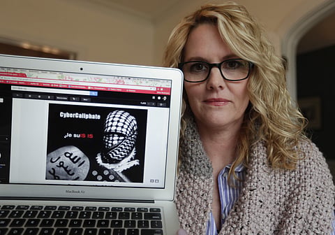 In this Monday, April 9, 2018, photo, Angela Ricketts poses with a screen shot of a message she received from a group claiming to be Islamic State supporters, in Bloomington, Ind. | Associated Press