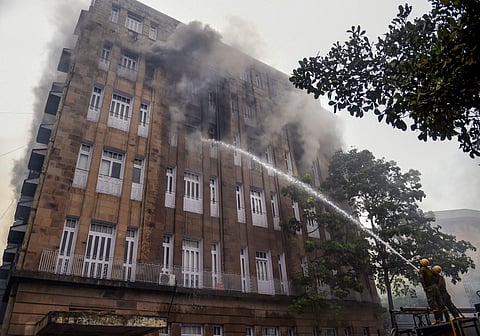 Firefighters try to douse a fire which broke out at Scindia House building in South Mumbai on Friday. (PTI)