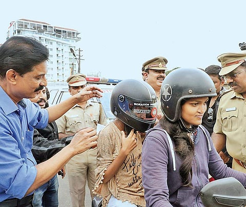 Deputy Transport Commissioner Shaji Joseph giving a helmet to a pillion rider as part of the helmet awareness project jointly organised by MVD and Freedom Riders in Kochi on Saturday | Melton  Antony