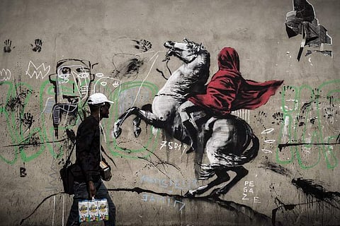 A man walks past a recent artwork by street artist Banksy in Paris on June 25, 2018. (Photo: AFP)