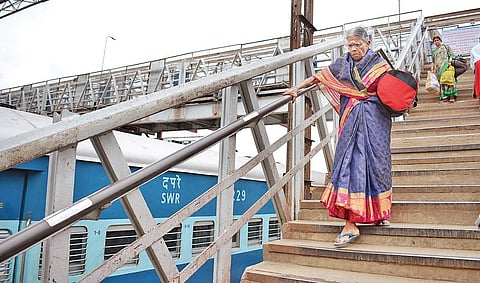 Passengers struggle with heavy baggage while walking from railway station to Metro station Shriram BN