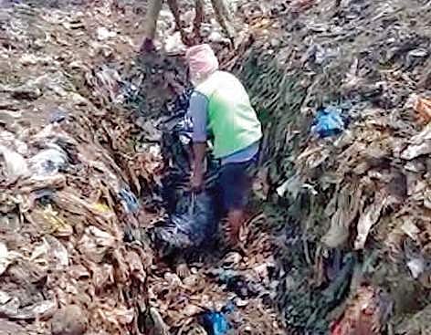 Karimnagar Municipal Corporation workers digging out the body of the man, who died in an accident, from a local dump yard on Monday | Express