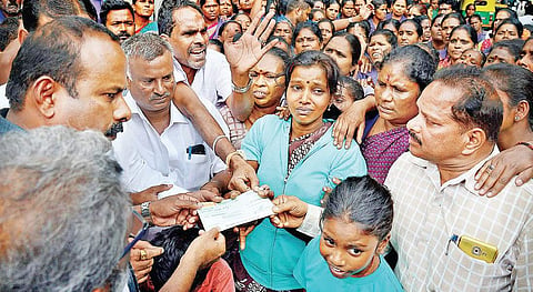 Mayor Sampath Raj hands over cheque to a teary Kavitha at KC General Hospital on Monday  | PUSHKAR V