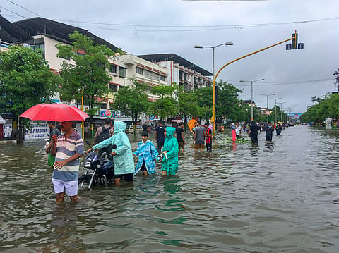 People wade through a flooded street following heavy rains in Vasai Maharashtra on Tuesday 10 July 2018. | PTI