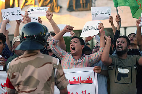 Iraqi protesters chant slogans demanding services and jobs during a demonstration in Tahrir Square. (Photo | AP)