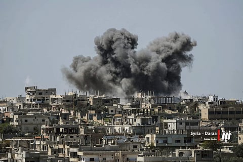 smoke rising over buildings that were hit by Syrian government forces bombardment, in Daraa province, southern Syria. ( Photo | AP)