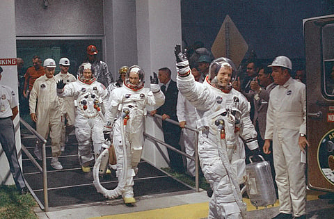 In this July 16, 1969, file photo, Neil Armstrong waving in front, heads for the van that will take the crew to the rocket for launch to the moon at Kennedy Space Center in Merritt Island. (File Photo | AP)