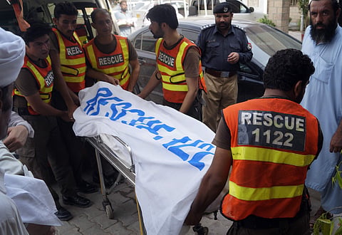 Rescue workers move the body of Ikramullah Gandapur. (Photo | AP)