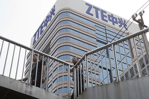 Chinese men pass by a ZTE building in Beijing, China (File Photo| AP)