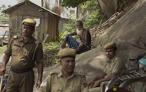 In this image, a Muslim man sits near security personnel as he arrives to check if his name is included in the National Register of Citizens at a draft center in Mayoung, about 55 kilometers (34 miles) east of Gauhati, India, Monday, July 30, 2018. | AP
