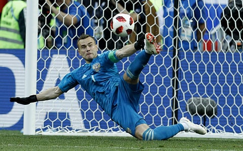 Russia goalkeeper Igor Akinfeev catches a penalty shot during the round of 16 match between Spain and Russia. Akinfeev saved two of Spain's five shots as the hosts shocked the 2010 champions in Moscow. | AP